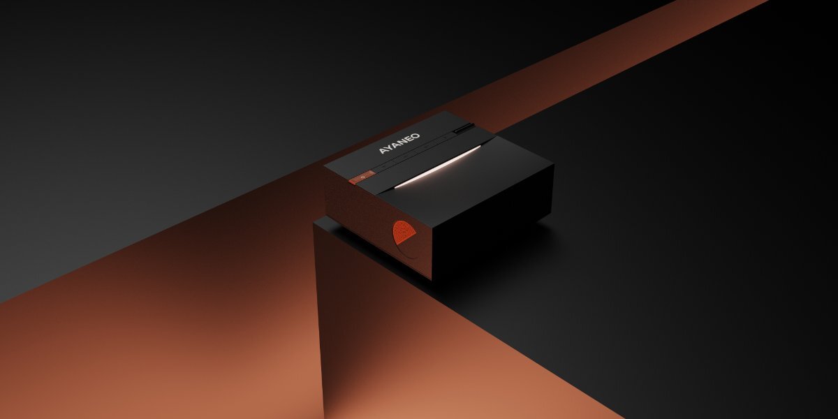 Czarna konsola AYANEO Mini PC AM03 16/512GB z widocznym logo AYANEO na górnej powierzchni, umieszczona na ciemnym tle z pomarańczowym akcentem.