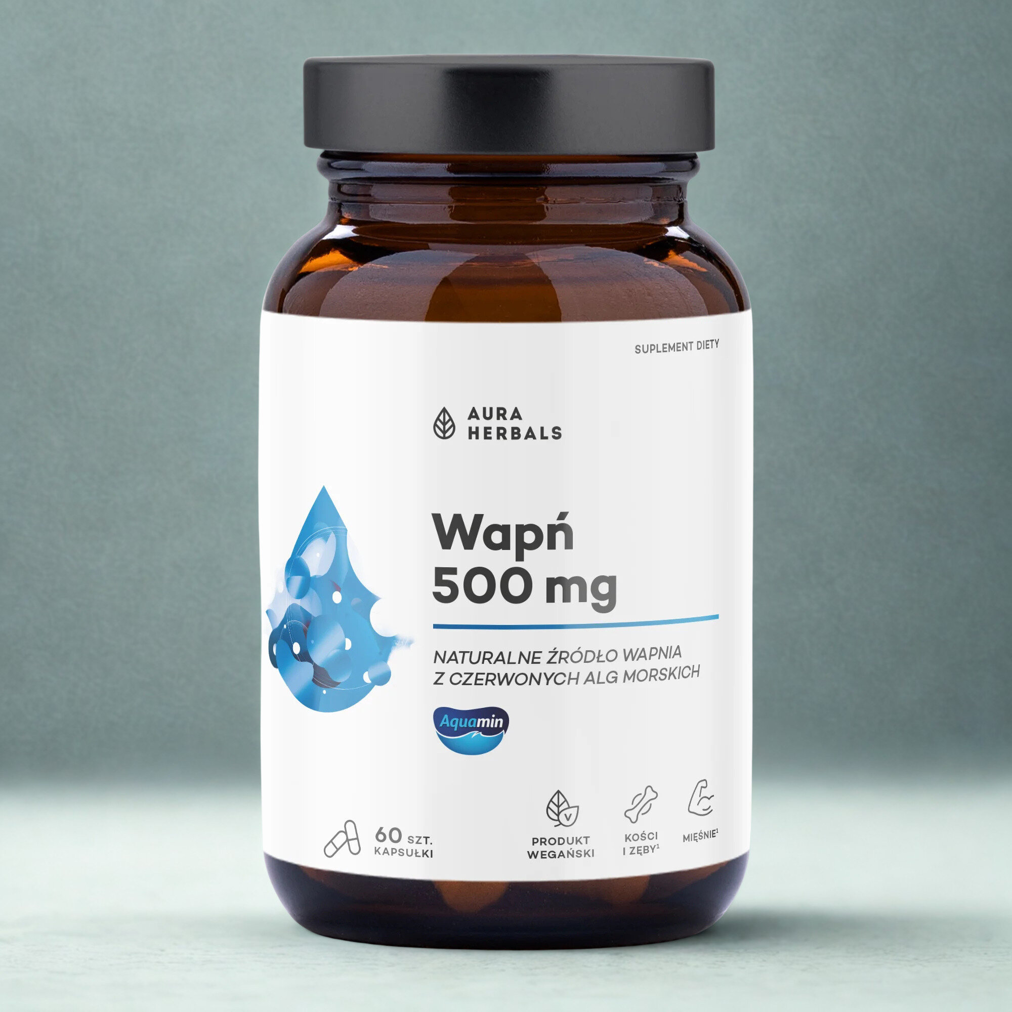Szklana butelka z ciemnego szkła z białą etykietą, na której widnieje napis: \'Aura Herbals Wapń 500 mg\'. Na etykiecie znajduje się również informacja: \'Naturalne źródło wapnia z czerwonych alg morskich\', oraz ikony oznaczające 60 szt. kapsułek, produkt wegański, kości i zęby, mięśnie.