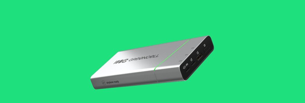 Srebrny powerbank z logo \'GREENCELL\' na zielonym tle. Posiada kilka portów na jednym z boków.