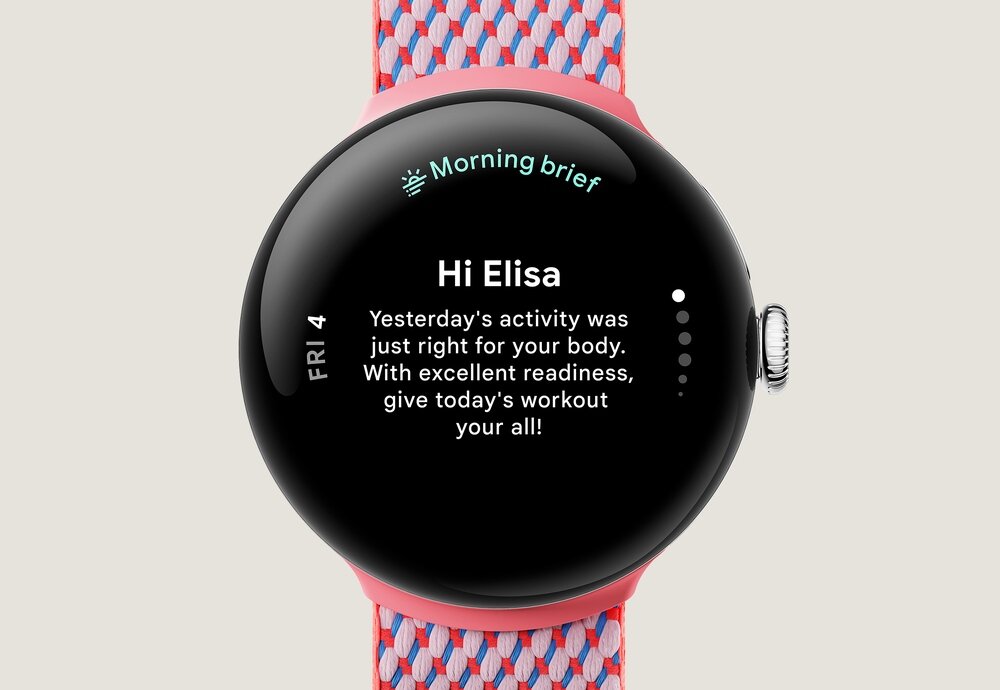Smartwatch z okrągłym wyświetlaczem pokazuje tekst: \'Morning brief\', \'Hi Elisa\', \'Yesterday\'s activity was just right for your body. With excellent readiness, give today\'s workout your all!\'. Pasek jest w kolorze różowo-niebieskim.
