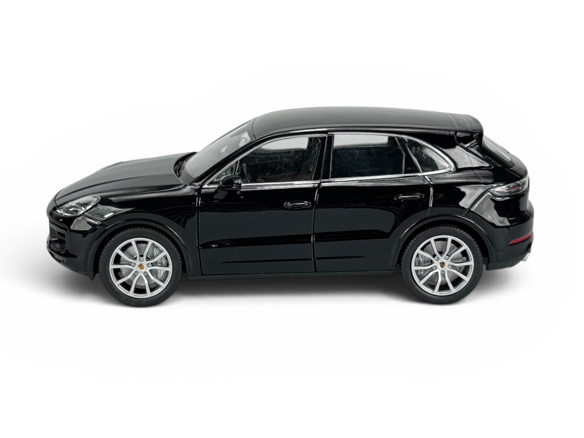 Czarny model samochodu w skali 1:24, przedstawiający SUV-a z widocznymi srebrnymi felgami i detalami karoserii. Model jest wykonany z metalu i ma realistyczne odwzorowanie szczegółów.