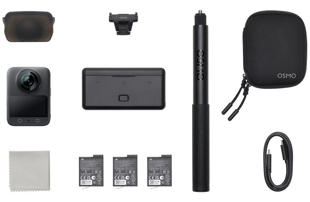 Na obrazie znajduje się zestaw akcesoriów do kamery sportowej, w tym kamera, etui z napisem \'OSMO\', uchwyt, trzy baterie, kabel, ściereczka oraz inne elementy montażowe. Wszystkie przedmioty są rozmieszczone na białym tle.