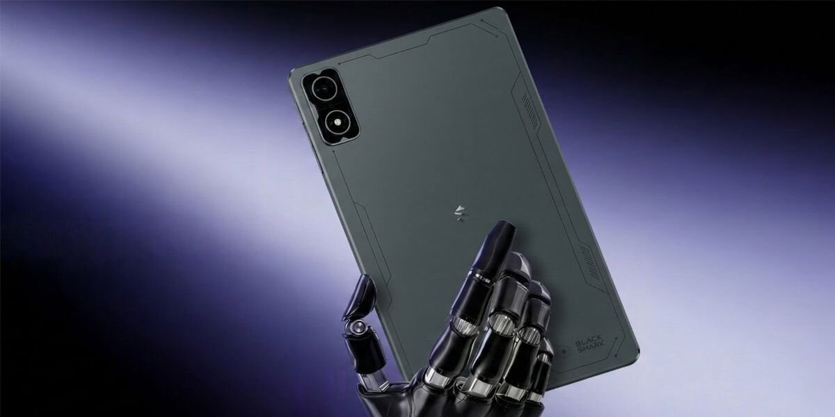 Na obrazie widać czarny tablet trzymany przez metaliczną rękę na tle gradientu fioletowo-białego. Na tablecie widoczne są dwa obiektywy aparatu oraz logo producenta.