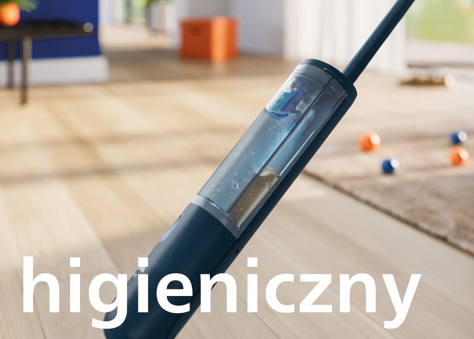 Na obrazie widoczny jest elektryczny mop z przezroczystym zbiornikiem na wodę, umieszczony na drewnianej podłodze. Na pierwszym planie znajduje się napis \'higieniczny\'.
