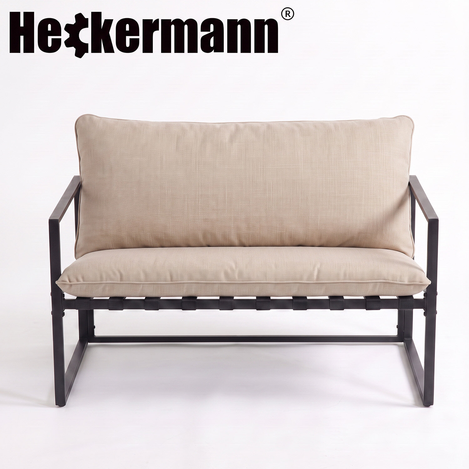 Na obrazie widoczna jest beżowa sofa z metalową ramą. W górnej części znajduje się logo \'Heckermann\'.