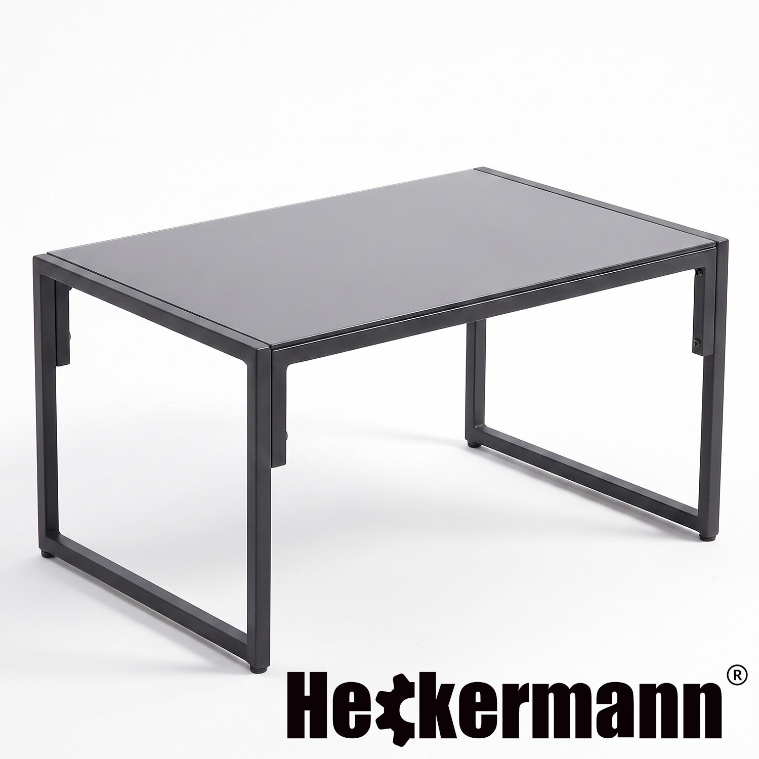 Prostokątny stół z metalową ramą i ciemnym blatem. Widoczne logo: Heckermann.