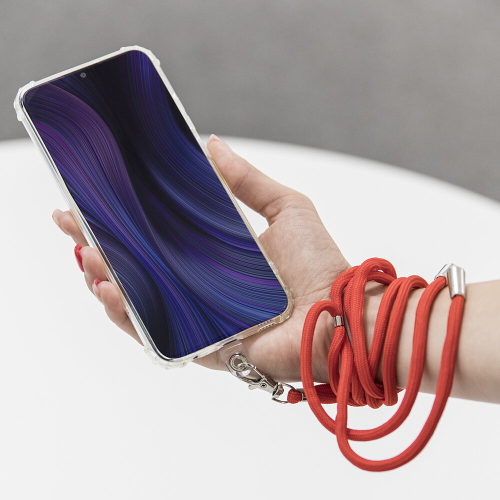 Osoba trzyma telefon z wyświetlaczem pokazującym abstrakcyjny wzór w odcieniach fioletu i niebieskiego. Telefon jest przymocowany do czerwonej smyczy owiniętej wokół nadgarstka.