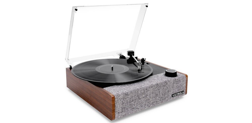 Gramofon z drewnianą obudową i przezroczystą pokrywą, z widocznym talerzem i ramieniem. Na przedniej części znajduje się logo \'VICTROLA\'.