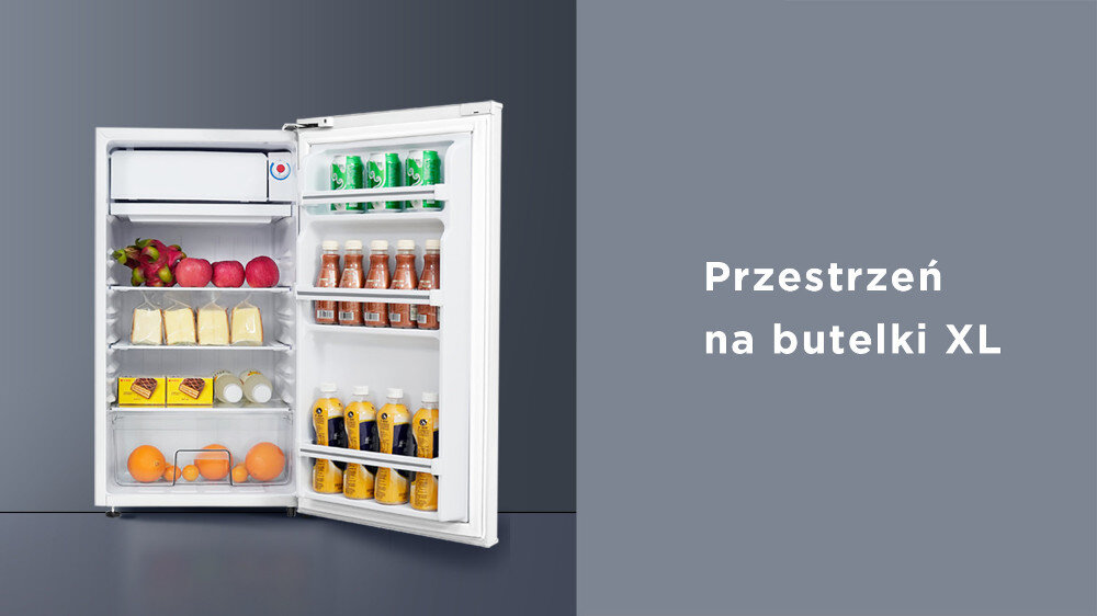 Otwarta biała lodówka z widocznymi półkami wypełnionymi różnymi produktami spożywczymi, w tym butelkami i owocami. Obok lodówki znajduje się napis: \'Przestrzeń na butelki XL\'.