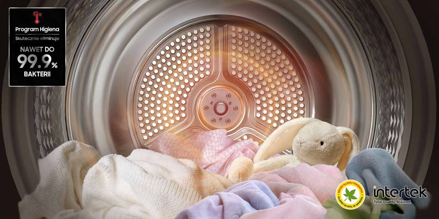 Program Higiena - skuteczna ochrona przed bakteriami Wnętrze bębna suszarki z widocznymi kolorowymi tkaninami i pluszowym królikiem. Po lewej stronie znajduje się napis: \'Program Higiena Skutecznie eliminuje NAWET DO 99.9% BAKTERII\', a w prawym dolnym rogu logo \'intertek\'.