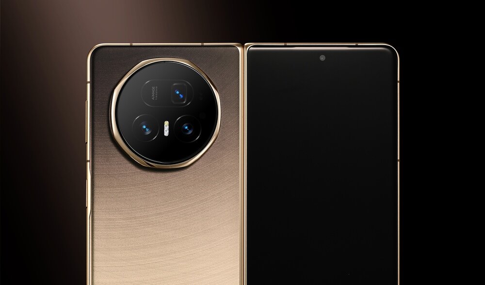 Obraz przedstawia złoty smartfon z dużym okrągłym modułem aparatu z trzema obiektywami. Ekran urządzenia jest wyłączony, a obudowa ma metaliczne wykończenie.