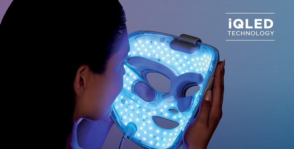 Osoba trzyma maskę LED emitującą niebieskie światło, z widocznymi otworami na oczy, nos i usta. W prawym górnym rogu znajduje się napis \'iQLED TECHNOLOGY\'.