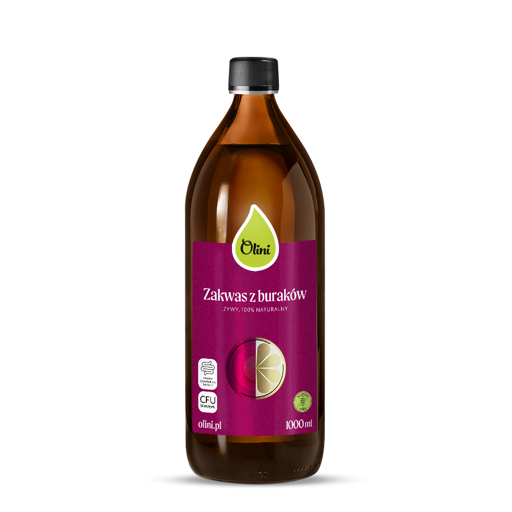 Butelka z ciemnego szkła z etykietą w kolorze bordowym, na której widnieje napis \'Olini Zakwas z buraków ŻYWY, 100% NATURALNY\'. Na etykiecie znajdują się również symbole oraz napis \'olini.pl\' i \'1000 ml\'.