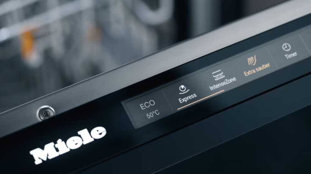 Panel sterowania zmywarki z widocznymi przyciskami: ECO 50°C, Express, IntenseZone, Extra sauber, Timer. Logo Miele znajduje się na obudowie.