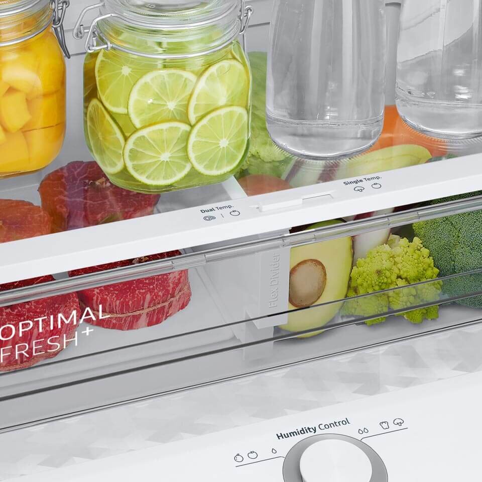Produkty spożywcze ułożone na półkach wykonanych z hartowanego szkła Wnętrze lodówki z widocznymi szklanymi pojemnikami z owocami i warzywami oraz napisem \'OPTIMAL FRESH+\'. Na panelu widoczne są napisy \'Dual Temp.\' i \'Single Temp.\' oraz pokrętło \'Humidity Control\'.