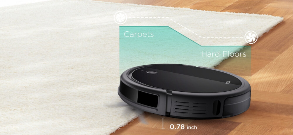 Czarny robot sprzątający znajduje się na granicy dywanu i twardej podłogi. Widoczny jest tekst: \'Carpets\', \'Hard Floors\', \'0.78 inch\'.