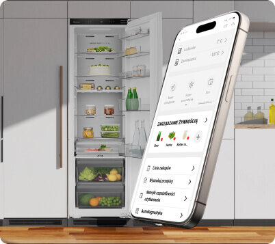 Na obrazie widoczna jest otwarta lodówka z różnymi produktami spożywczymi oraz smartfon z aplikacją do zarządzania żywnością. W tle znajduje się kuchnia z białymi szafkami i drewnianym blatem.