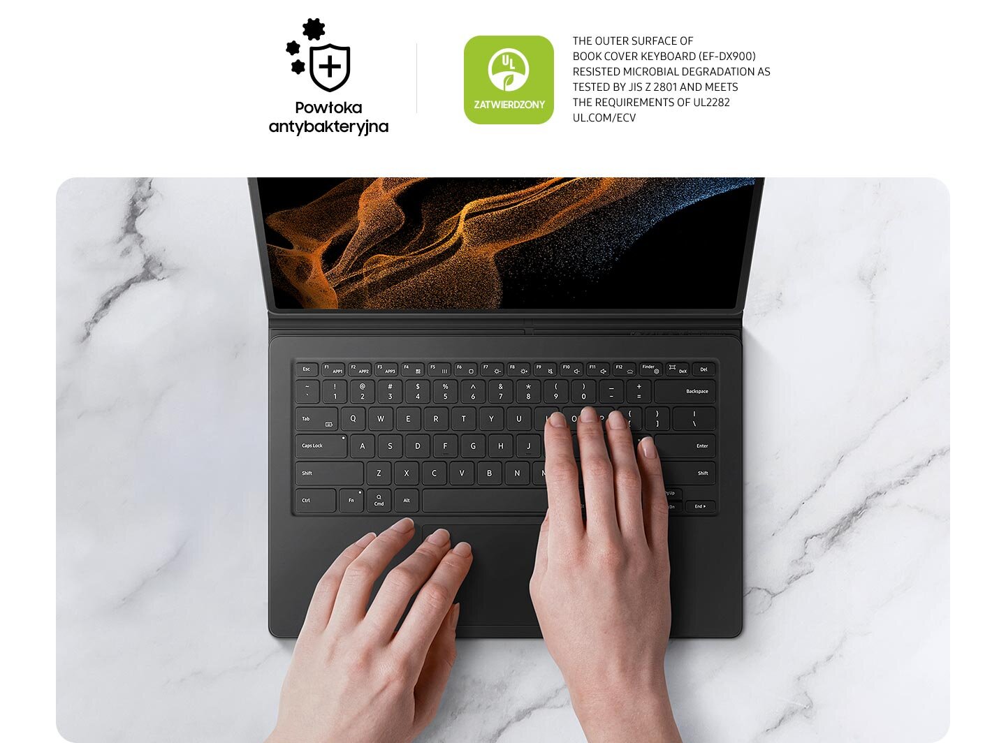 phpayy8lq zegnajcie-mikroby Osoba używa czarnej klawiatury z etui na tablecie, na ekranie widoczny jest abstrakcyjny wzór. Na górze obrazu znajdują się napisy: \'Powłoka antybakteryjna\' oraz \'Zatwierdzony\', a także tekst w języku angielskim dotyczący odporności na degradację mikrobiologiczną.