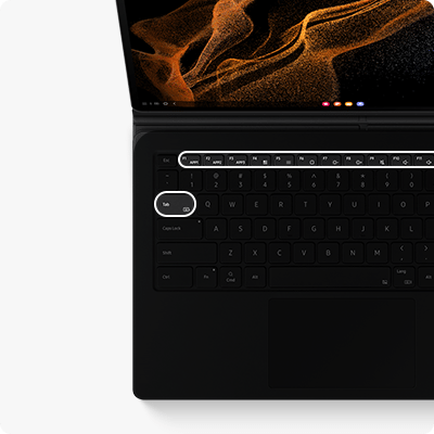 phpufdayx 17-intuitive-function-keys Czarna klawiatura z podświetlonym klawiszem \'Tab\' i widocznym touchpadem. Na ekranie urządzenia wyświetlany jest abstrakcyjny wzór w kolorach pomarańczowym i czarnym.