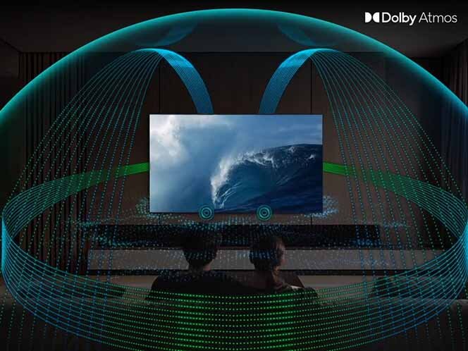 Na obrazie widać telewizor wyświetlający obraz fali na morzu, z efektami dźwiękowymi Dolby Atmos wizualizowanymi jako linie wokół ekranu. W prawym górnym rogu znajduje się logo \'Dolby Atmos\'.