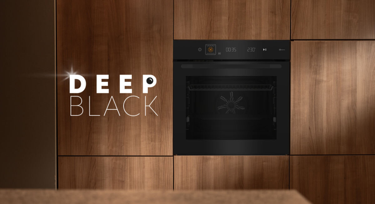 Czarny piekarnik elektryczny wbudowany w drewnianą zabudowę kuchenną. Obok piekarnika widoczny jest napis \'DEEP BLACK\'.