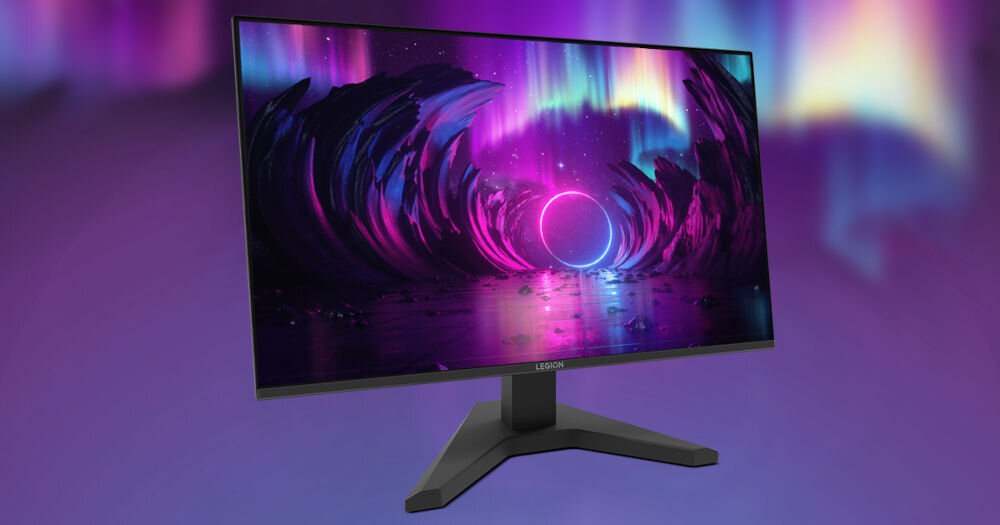 Monitor z wyświetlaczem przedstawiającym kolorową grafikę z efektem świetlnym przypominającym zorze. Na podstawie monitora widoczne jest logo \'LEGION\'.
