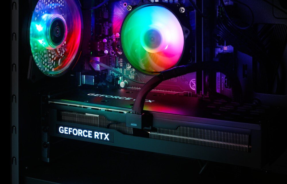 Wnętrze komputera z widoczną kartą graficzną oznaczoną napisem \'GEFORCE RTX\' oraz wentylatorami z podświetleniem RGB.
