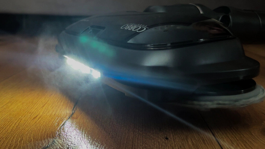 Na drewnianej podłodze znajduje się urządzenie z widocznym logo \'COBBO Ultra Steam UV\', emitujące parę i światło LED.