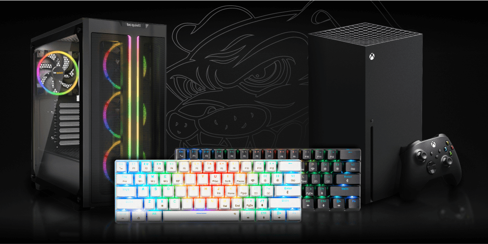 Na obrazie znajduje się klawiatura z podświetleniem RGB, obok której stoi czarna konsola do gier z kontrolerem oraz komputer z przezroczystym panelem i podświetleniem. W tle widoczne jest logo w kształcie stylizowanej głowy psa.