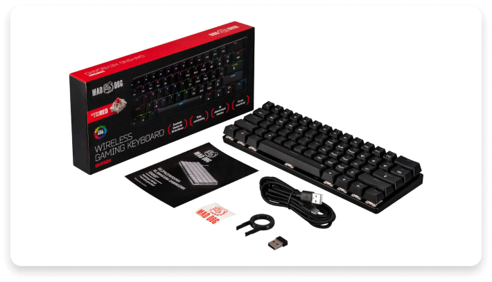 Na obrazie znajduje się czarna klawiatura mechaniczna z czerwonymi przełącznikami, opakowanie z napisem \'MAD DOG WIRELESS GAMING KEYBOARD\', kabel USB, klucz do wyjmowania klawiszy, naklejka oraz adapter USB. Widoczne jest logo \'MAD DOG\' na opakowaniu.