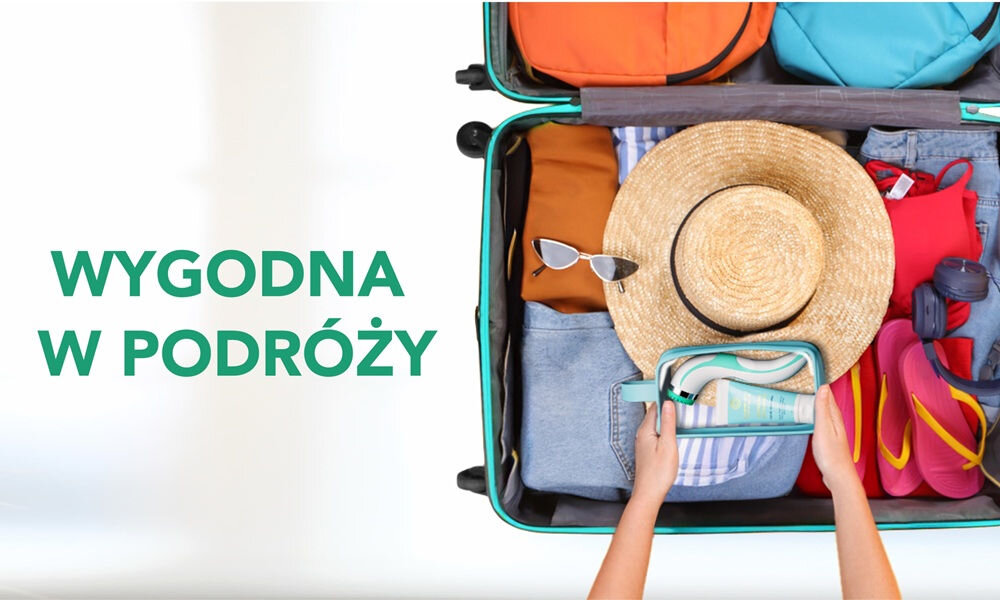 Walizka wypełniona ubraniami, kapeluszem, okularami przeciwsłonecznymi i klapkami. Obok widoczny napis: \'WYGODNA W PODRÓŻY\'.