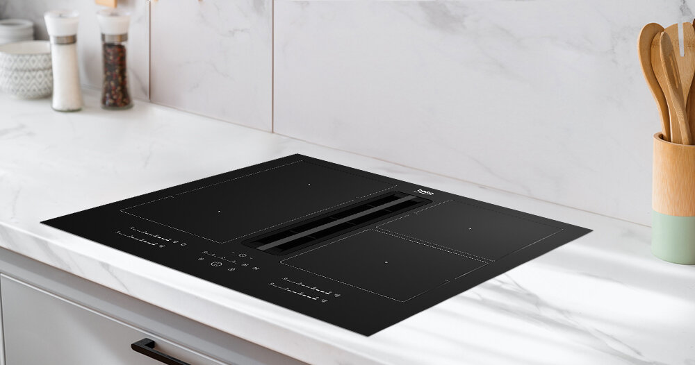 Czarna płyta indukcyjna z wbudowanym okapem, umieszczona na białym blacie kuchennym. Na płycie widoczne są oznaczenia pól grzewczych oraz logo BEKO.