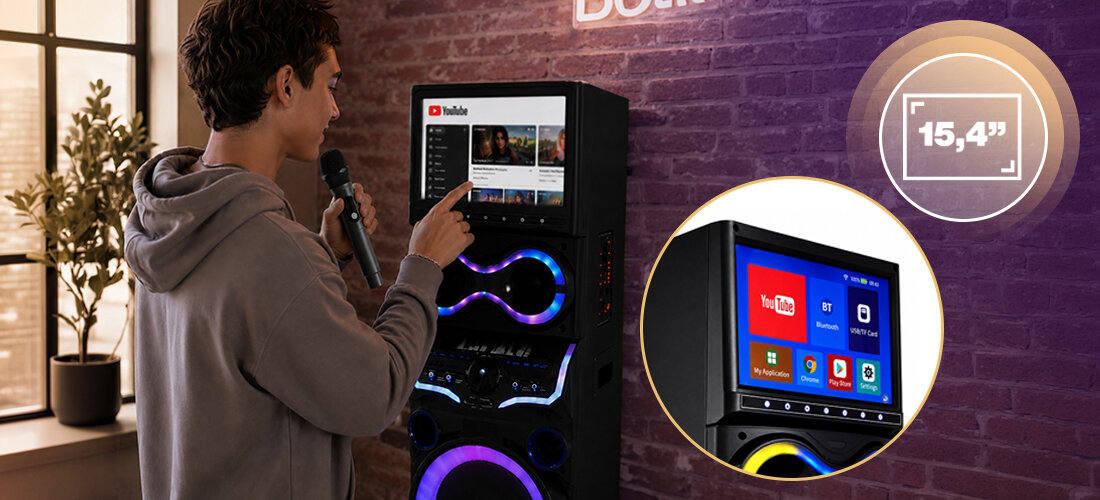 Power Audio MUSICMATE KTV MM-SC1500, moc RMS 160 W, dwa 12-calowe subwoofery, konstrukcja tower, regulacja basu i tonów wysokich, power audio stojące na ziemi w pomieszczeniu, osoba trzymająca mikrofon w ręku