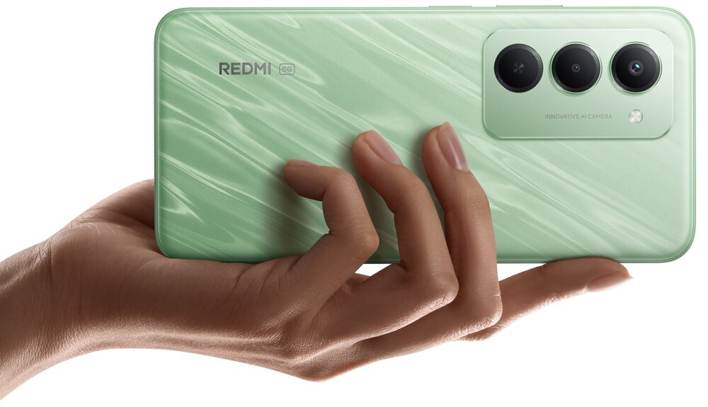 Osoba trzyma zielony smartfon z trzema obiektywami aparatu i napisem \'REDMI 5G\'.