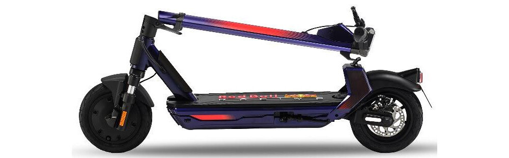 Elektryczna hulajnoga w kolorze niebieskim z czerwonymi akcentami, z widocznym logo Red Bull Racing na platformie. Posiada duże koła i amortyzację, a kierownica jest złożona.