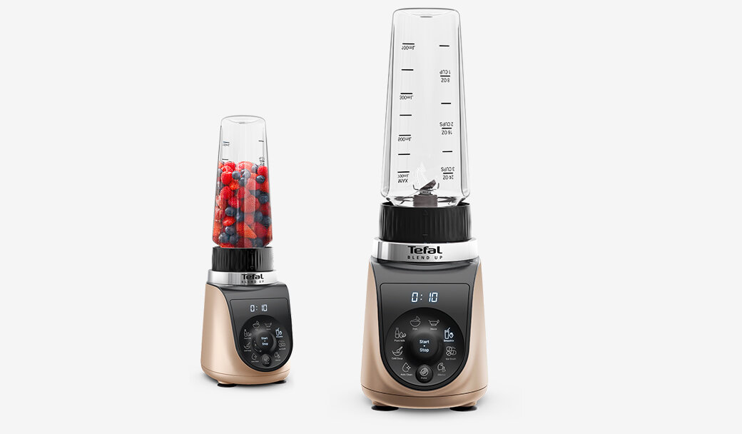Na obrazie widoczne są dwa blendery marki Tefal z przezroczystymi pojemnikami, jeden z nich zawiera czerwone i niebieskie owoce. Na panelu sterowania widoczne są przyciski i wyświetlacz z czasem 0:10.