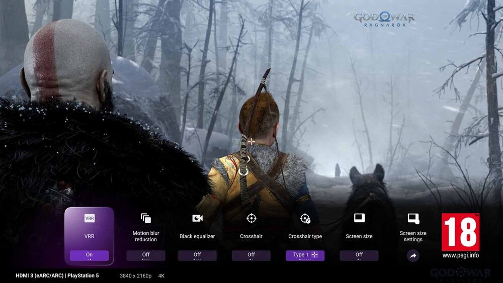 Obraz przedstawia dwóch postaci stojących w zimowym lesie, z widocznymi ustawieniami ekranu na dole, takimi jak VRR, Motion blur reduction, Black equalizer, Crosshair, Crosshair type, Screen size i Screen size settings. W prawym górnym rogu znajduje się logo \'God of War Ragnarok\', a w prawym dolnym rogu oznaczenie wiekowe 18 oraz adres strony www.pegi.info.