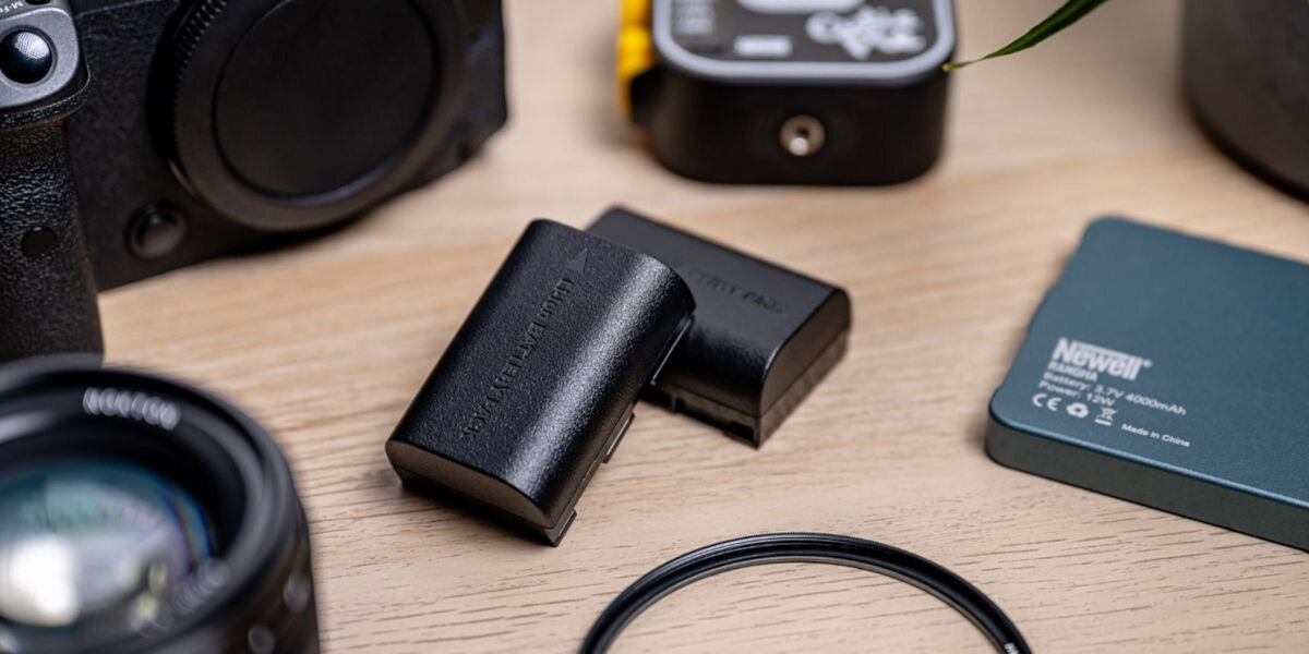 Akumulator NEWELL 1050 mAh do Pentax D-Li109, akumulator, newell, energia, aparat, akumulatory leżą na blacie wśród sprzętu elektronicznego