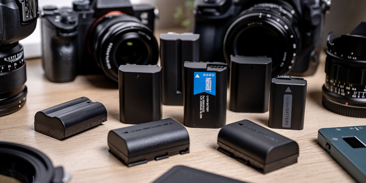 Akumulator NEWELL 1860 mAh do Pentax D-LI90, ogniwa, pojemność, ochrona, ładowanie, akumulatorki leżą wśród sprzętu fotograficznego