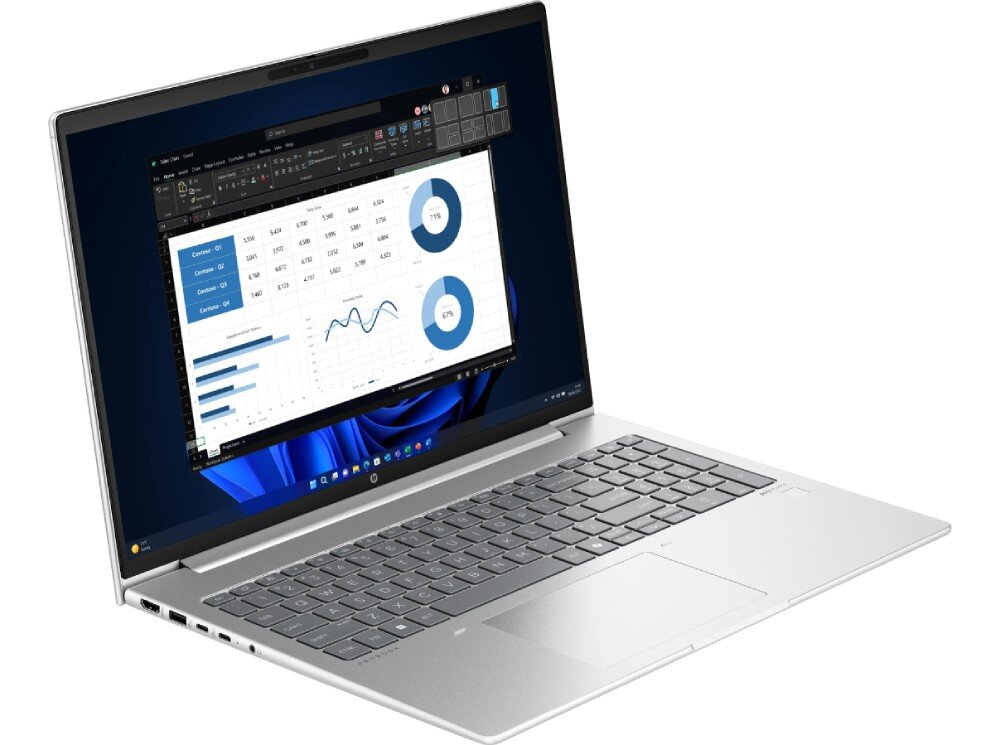 Laptop z otwartym ekranem wyświetlającym wykresy i dane w arkuszu kalkulacyjnym. Klawiatura jest pełnowymiarowa, a obudowa ma srebrny kolor.
