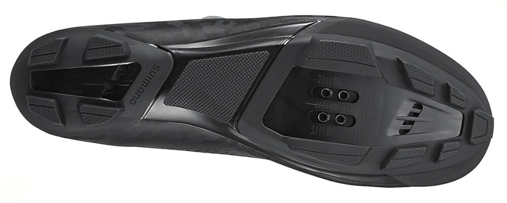 Czarna podeszwa buta rowerowego z widocznymi otworami na bloki i tekstem \'SHIMANO\'.