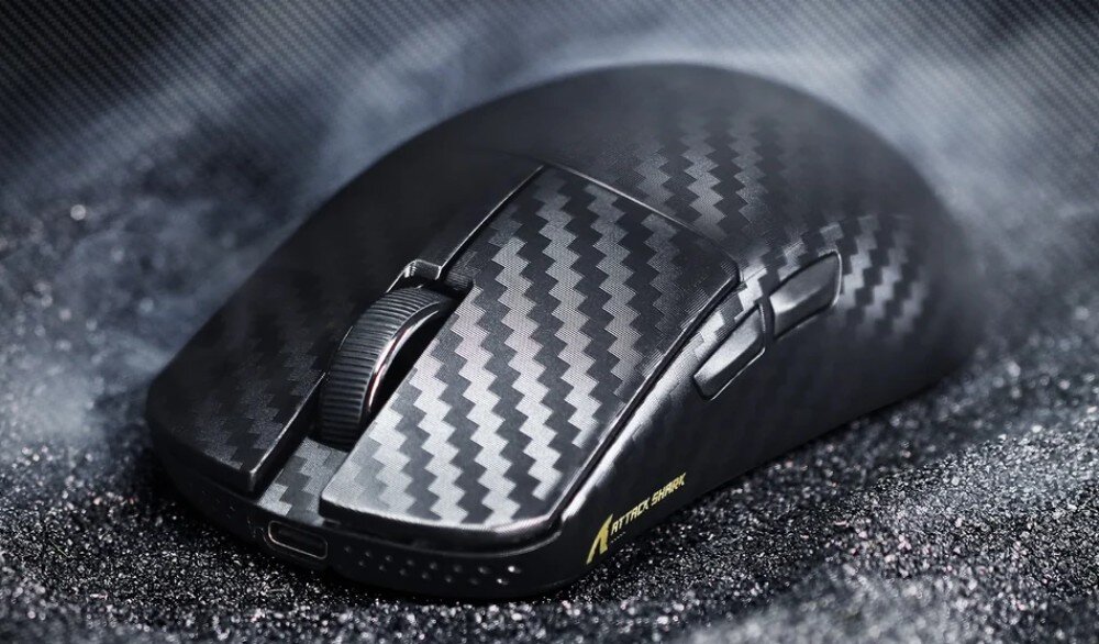 Mysz ATTACK SHARK R11 Ultra Weave Mysz komputerowa z dwoma przyciskami bocznymi i rolką, leżąca na ciemnym podłożu przypominającym piasek