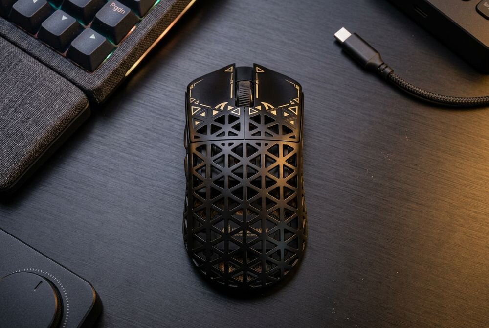 ATTACK SHARK R5 Częstotliwość odświeżania do 8000 Hz mikrokontroler Nordic 52840 bezprzewodowo 8000 Hz dedykowanego odbiornika 2,4 GHz USB-C kabla USB-A–USB-C - Widok z góry na perforowane urządzenie wskazujące ułożone na blacie