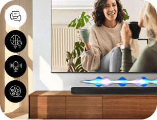 Na drewnianej szafce stoi czarny soundbar z kolorowymi falami świetlnymi. Obok widać ekran z dwoma osobami pijącymi napoje, a po lewej stronie znajdują się cztery okrągłe ikony z symbolami: dymek, piłka do koszykówki, mikrofon i film.