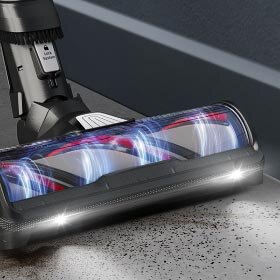 Odkurzacz z widoczną szczotką i oświetleniem LED, zbierający drobinki z podłogi. Na urządzeniu widoczny jest napis \'AeroSpin\'.