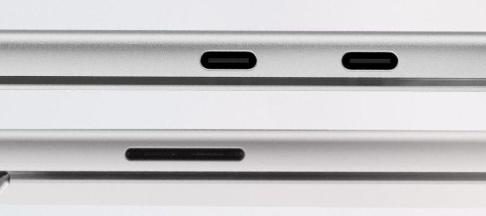 Obraz przedstawia dwa srebrne urządzenia elektroniczne z widocznymi portami USB-C na krawędziach. Górne urządzenie ma dwa porty, a dolne jeden.