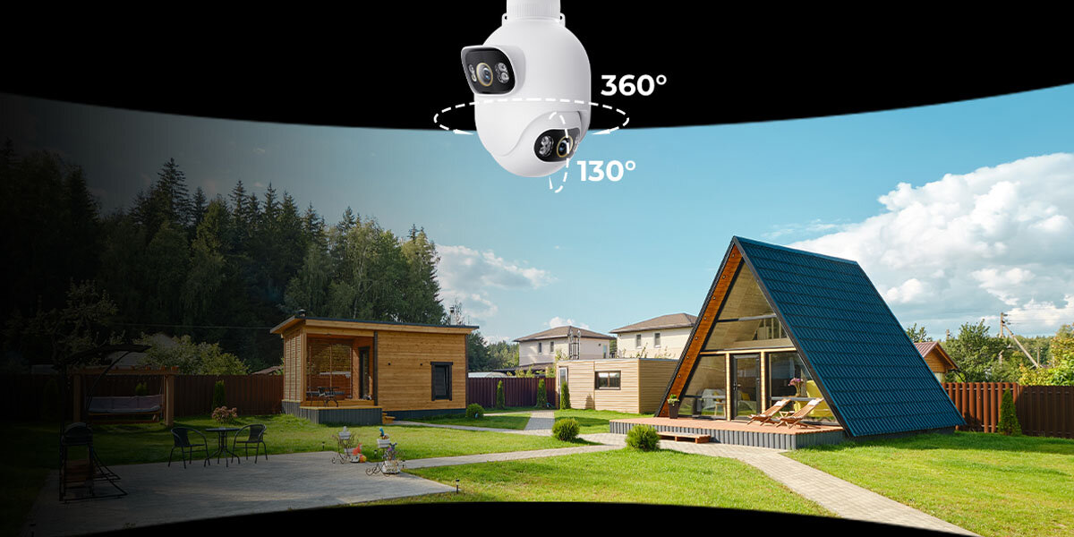 Na obrazie widoczna jest zewnętrzna kamera IP zamontowana nad podwórkiem z domami, z oznaczeniami kątów obrotu 360° i 130°. W tle znajdują się drewniane budynki i trawnik.