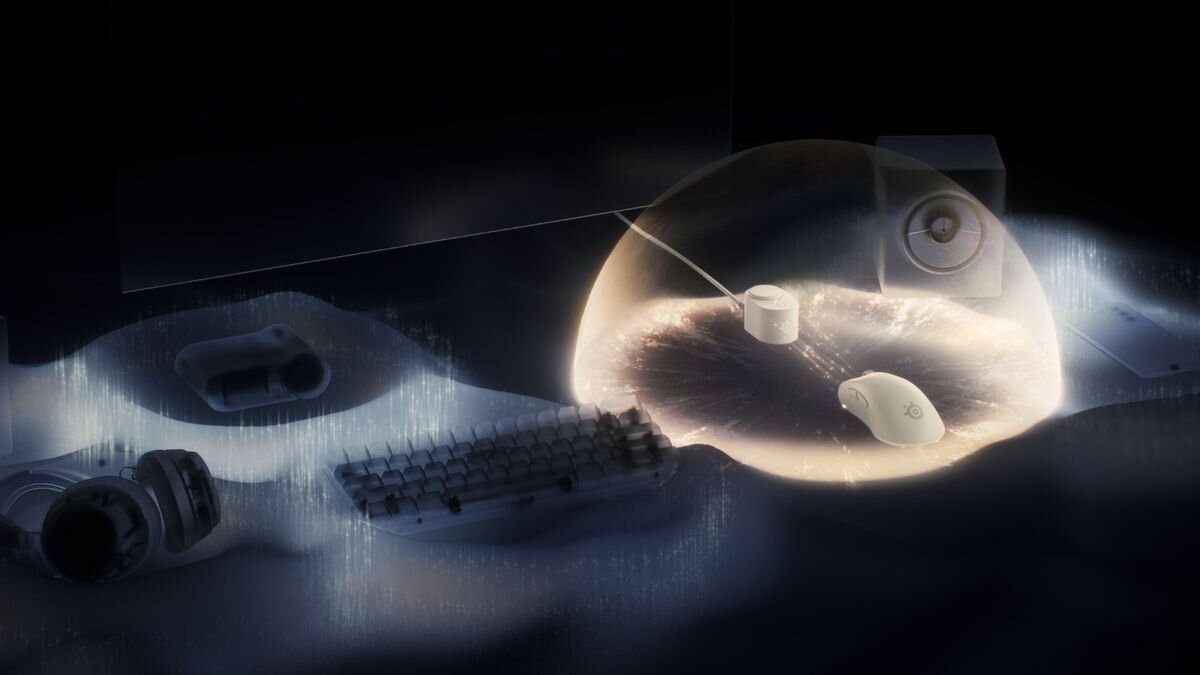 Na obrazie widać białą mysz komputerową z logo producenta, otoczoną świetlistą aurą. W tle znajdują się klawiatura, słuchawki i głośnik, wszystko w ciemnym otoczeniu.