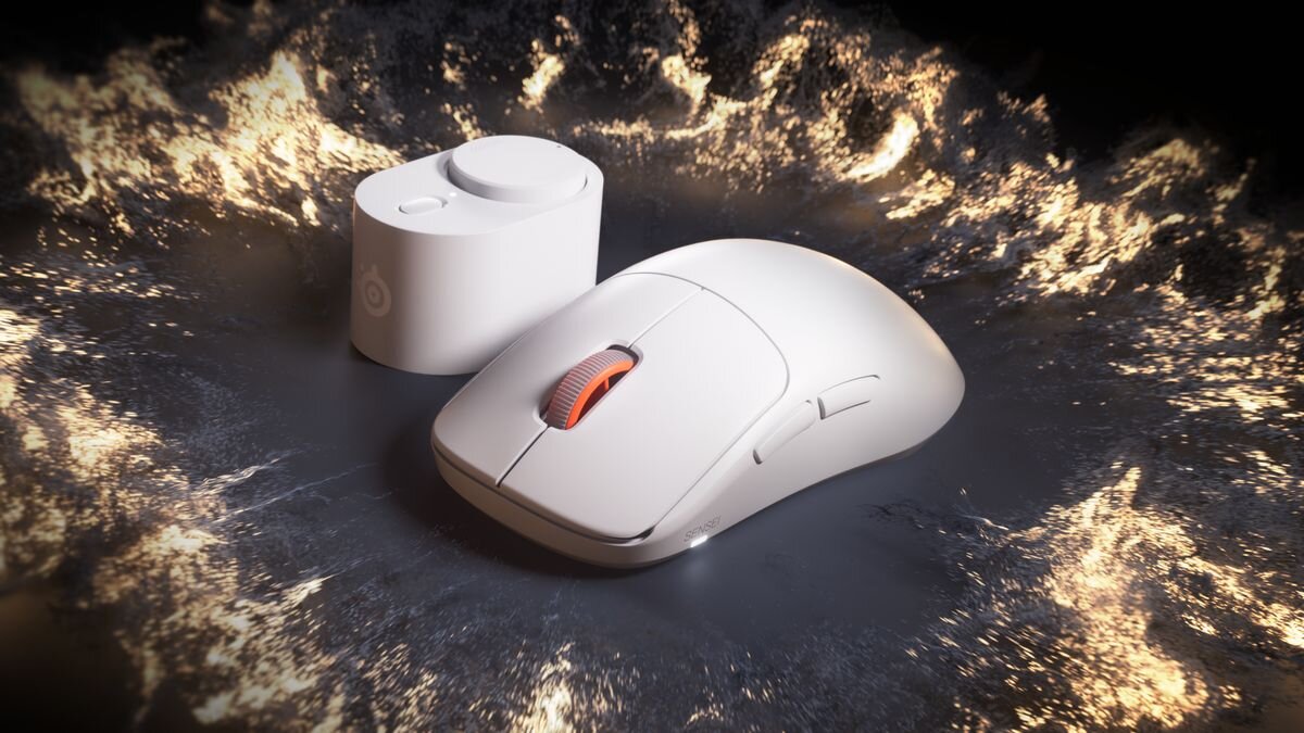 Na obrazie widoczna jest biała mysz komputerowa z pomarańczowym kółkiem przewijania oraz biały element z logo SteelSeries. Tło jest ciemne z jasnymi, płomienistymi wzorami.