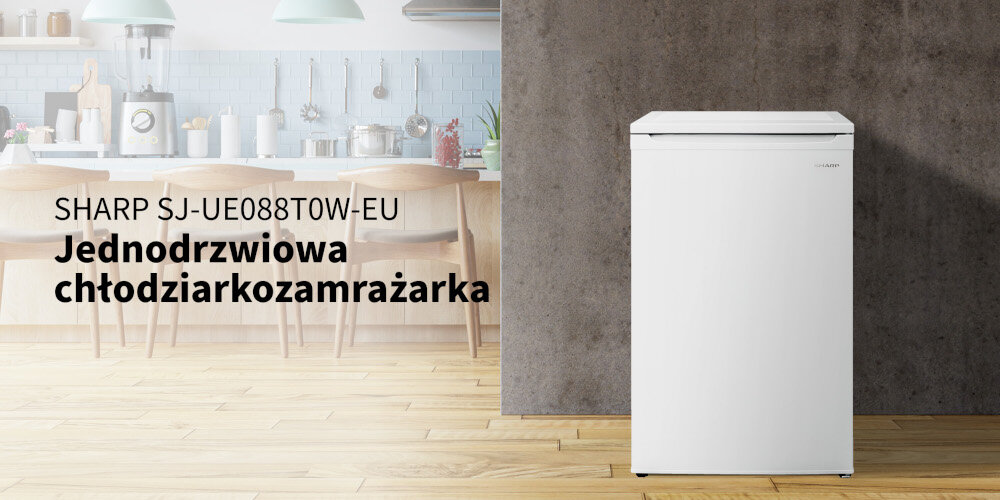 Biała lodówka SHARP SJ-UE088T0W-EU stoi na drewnianej podłodze, obok widoczna jest kuchnia z drewnianymi krzesłami i niebieskimi płytkami na ścianie. Tekst na obrazie: \'SHARP SJ-UE088T0W-EU Jednodrzwiowa chłodziarkozamrażarka\'.